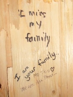 "We are all your family" written on the wall of the Embrace statue