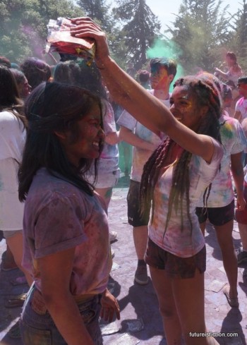 at Holi festival a girl dumps color into another girl's hair.
