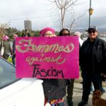 Hot pink protest sign at WOmens March Oakland says Femmes Against Fascism