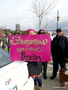 Hot pink protest sign at WOmens March Oakland says Femmes Against Fascism