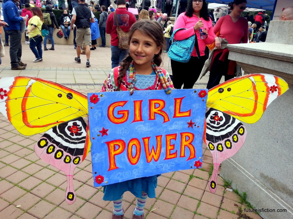 Little girl with Girl Power sign with homemade butterfly wings