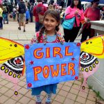 Little girl with Girl Power sign with homemade butterfly wings