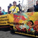 Oakland Women's March: woman holding climate mobilization banner