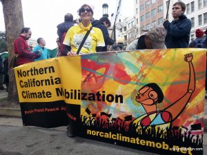 Oakland Women's March: woman holding climate mobilization banner