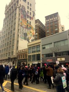 Oakland Women's March protestors with huge mural in background. Downtown Oakland