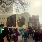 Downtown Oakland mural with Womens March in background