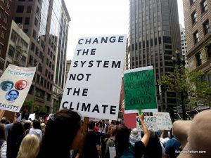 "change the system not the climate" protest sign