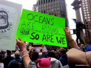 "Oceans are rising and so are we" protest sign