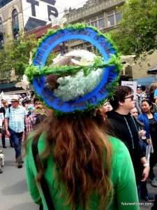 Homemade earth-shaped hat reads: Earth is round * Science is sound * Climate change is real * wake up!