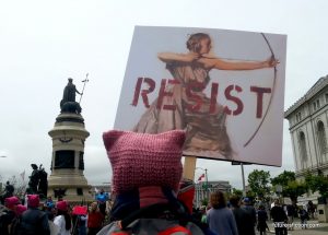 pink pussy hatted protester with a RESIST sign