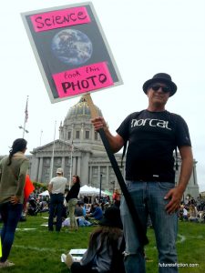 Protest sign with photo of the earth captioned "This photo brought to you by science"