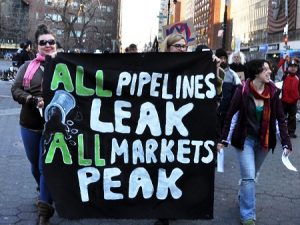 climate justice sign: All pipelines leak, all markets peak